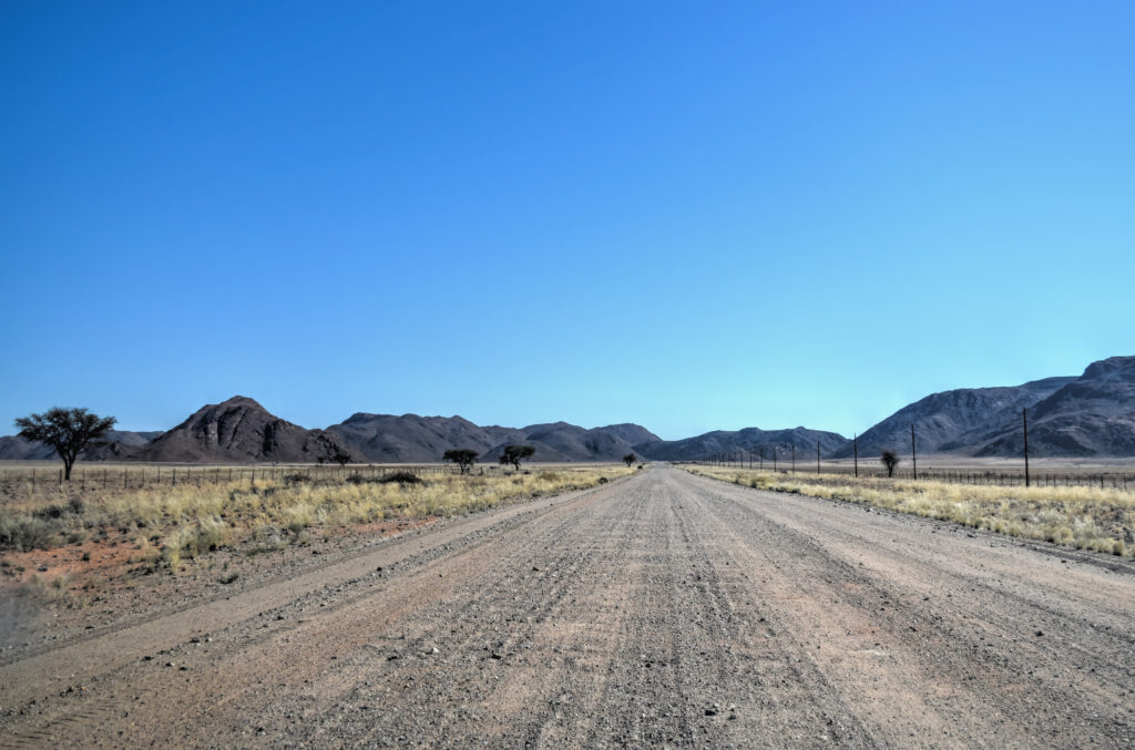 gravel road trip driving namibia travel desert landscape