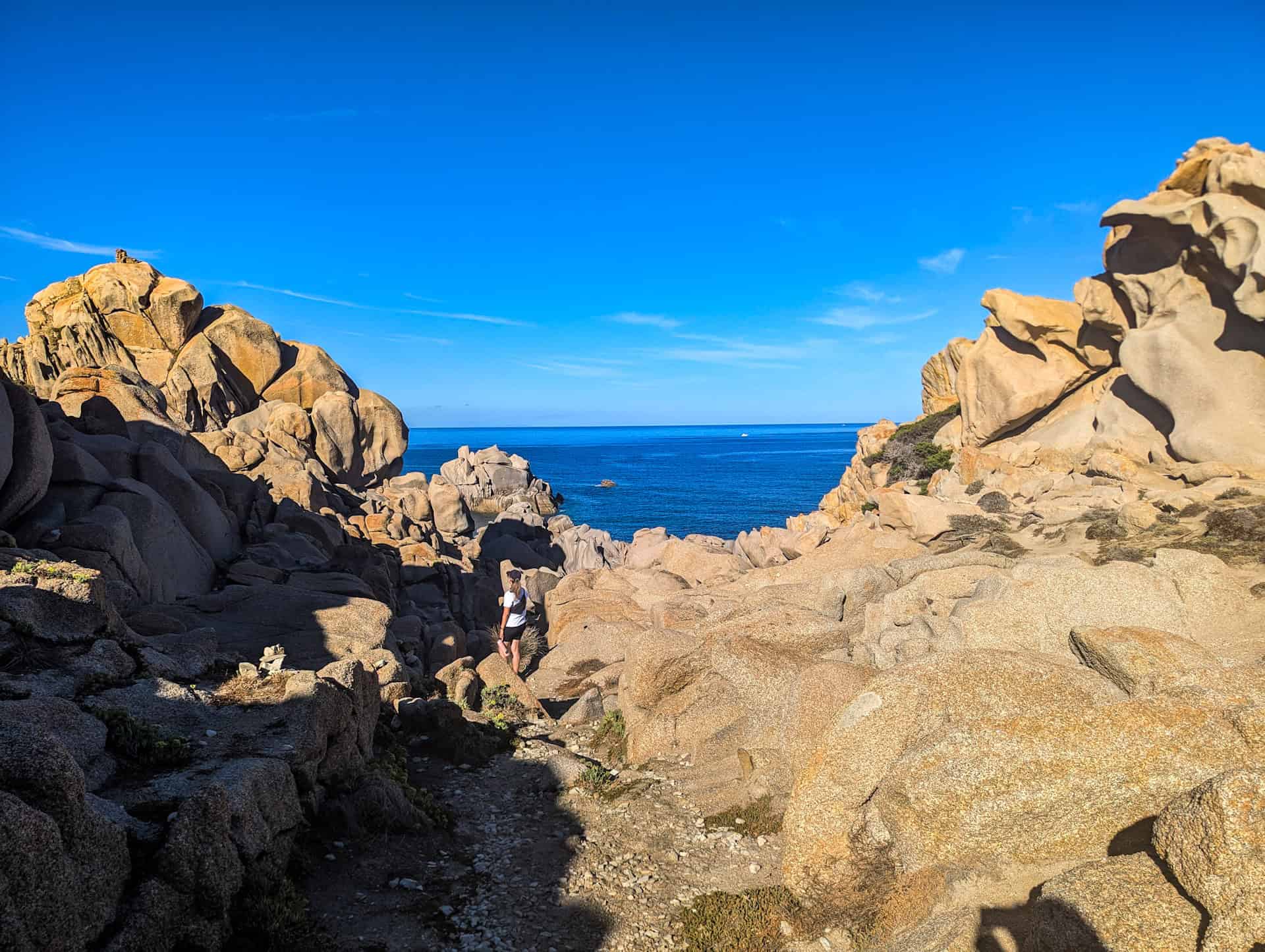 scrambling over the rocks in capo testa