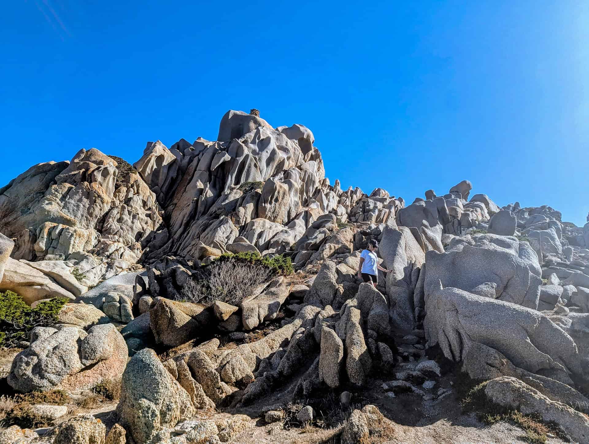 scrambling over the rocks in capo testa
